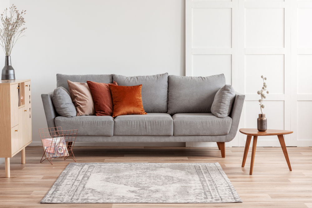Cuscini e tappeto su un divano grigio - Arredamenti Bleve